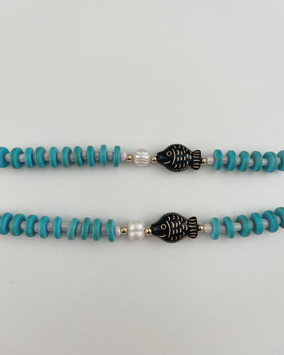 Turquoise and silver beaded bracelets on a light gray background