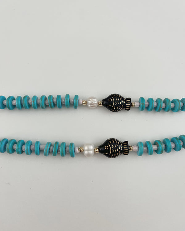 Turquoise and silver beaded bracelets on a light gray background