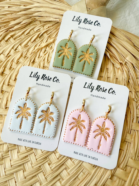 Set of three pairs of earrings on Lily Rose Co. cards against a woven background