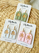 Set of three pairs of earrings on Lily Rose Co. cards against a woven background