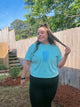 Person wearing a light blue t-shirt with a jellyfish design outdoors.