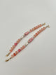 Beaded bracelets with pink, white, and gold beads on a white background