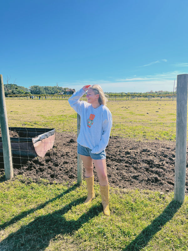 Person standing in a field with a clear blue sky