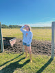 Person standing in a field with a clear blue sky